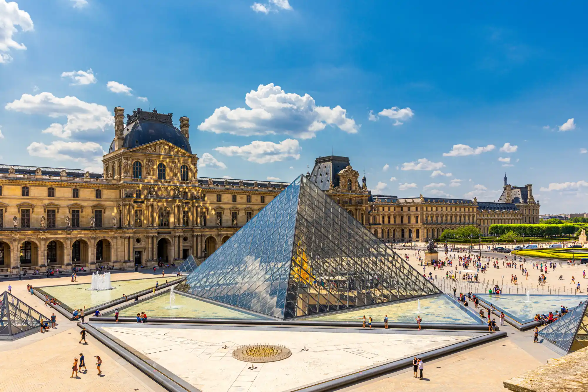 La pyramide de verre du Louvre dans la cour Napoléon, sous un ciel bleu