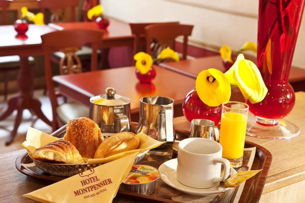 Plateau de petit-déjeuner avec viennoiseries, café et jus d'orange dans la salle de l'hôtel