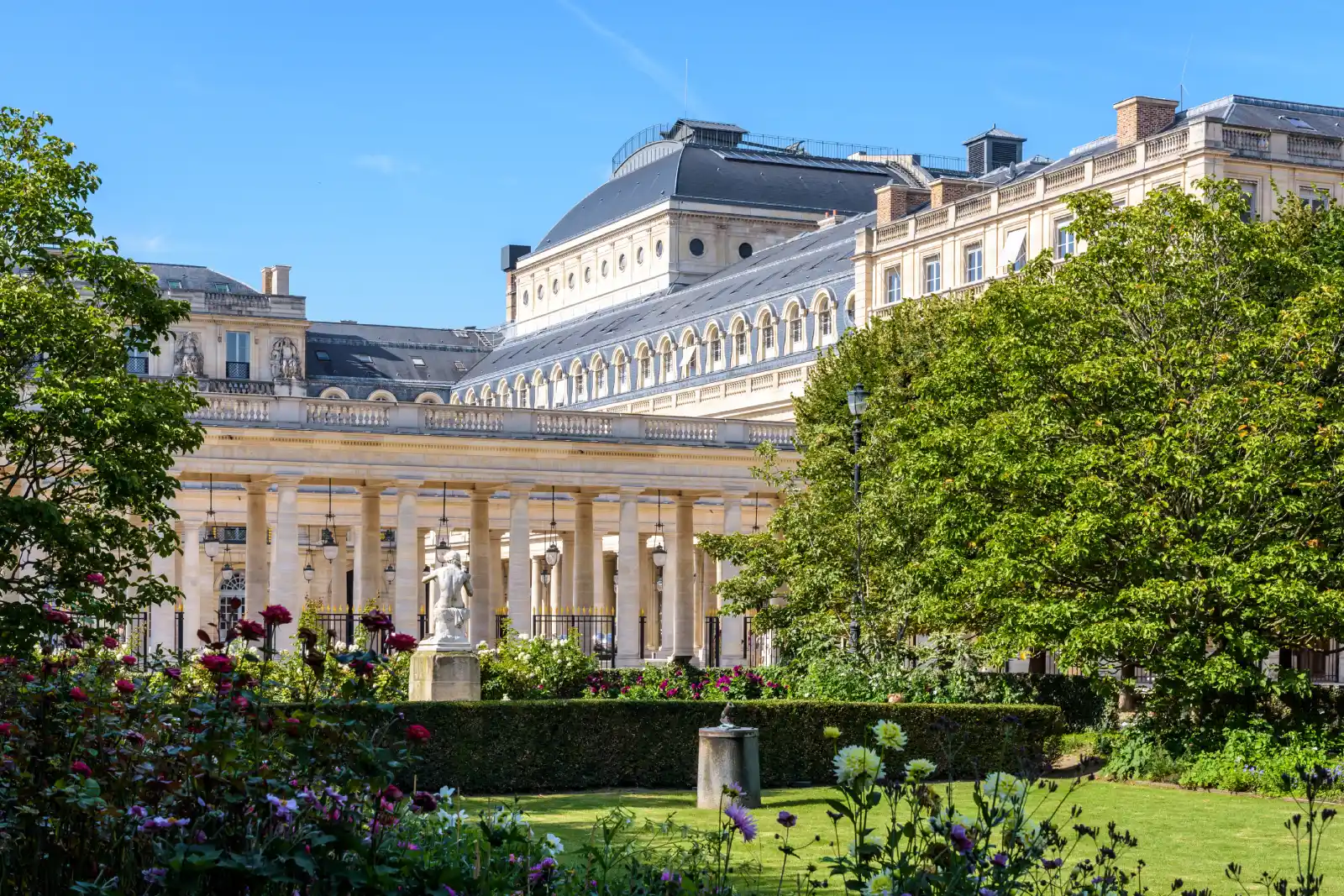 Jardin du Palais-Royal avec massifs de roses, pelouse et galeries à colonnades